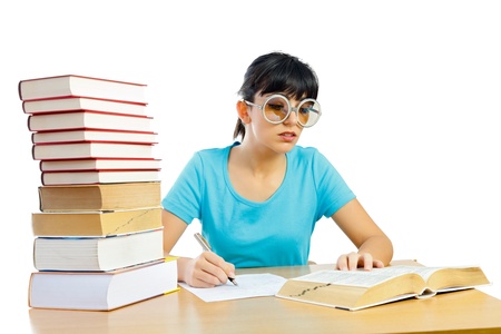 Beautiful girl with funny glasses writing on wooden table isolated on white - part of a series.の写真素材