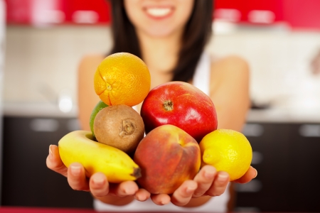 Young woman holding a handful fruits beginning her diet.の写真素材