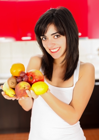 Young woman holding a handful fruits beginning her diet.の写真素材