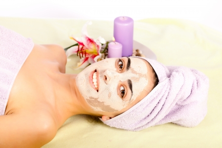 Lying beautiful woman at spa with clay mask on smiling.の写真素材