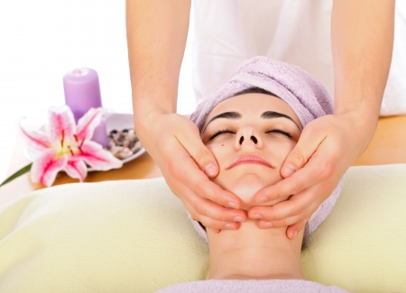 Beautiful young woman at spa receiving massage.の写真素材