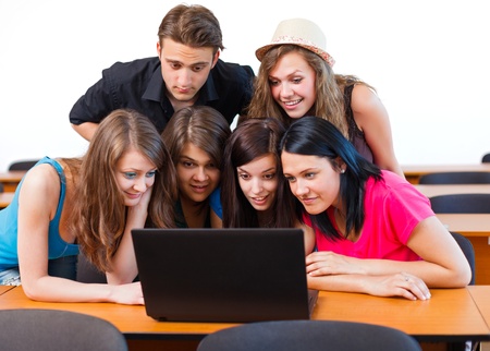 Students looking surprised at the laptop's screen.