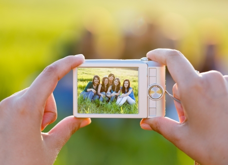 Lady hands taking photo of the group sitting on grass - groupphoto series.の写真素材