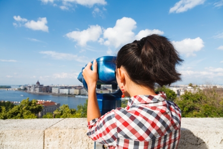 Woman seeing the city over a river through binocular.の写真素材