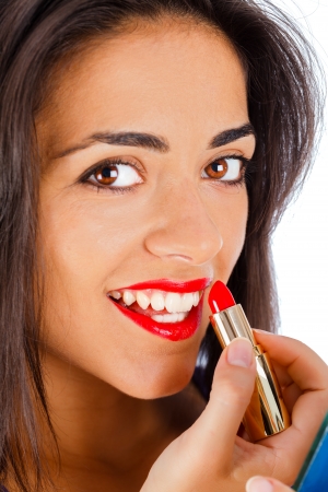 Beautiful brunette girl making the finishing touches for her make-up.の写真素材