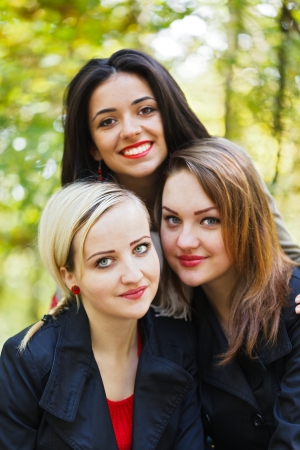 Beautiful girl friends together outdoors in a park on an autumn day.の写真素材