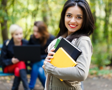 Pretty student girl with friends outdoors in the univesity campus.の写真素材