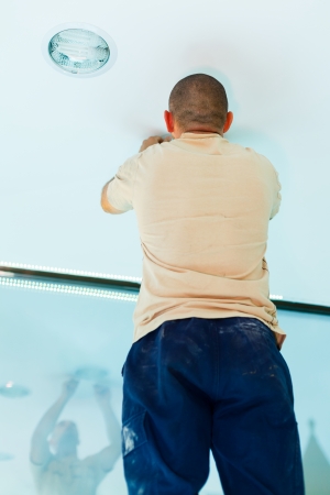 Electrician man assembling ecological light in homes.の写真素材