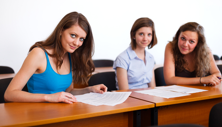 Cute classmates in classroom sitting at their desks.の写真素材