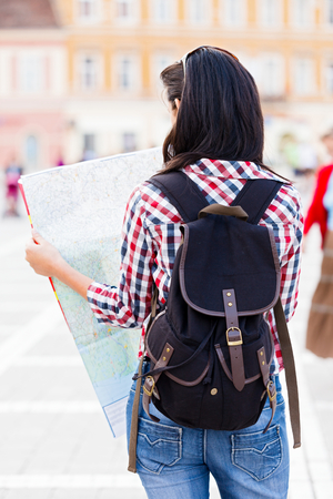 Tourist with backpack looking at the map of the city.の写真素材