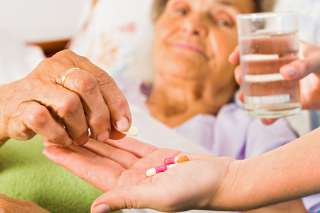 Supplements in nurse's hands for weak senior woman.の写真素材