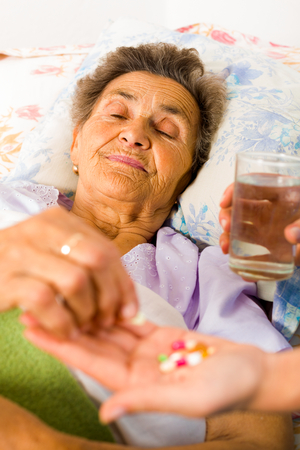 Supplements in nurse's hands for weak senior woman.の写真素材
