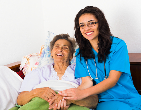 Caring nurse having fun with kind elderly patient.の写真素材