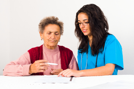 Nurse helping elderly with contract entering nursing home.の写真素材