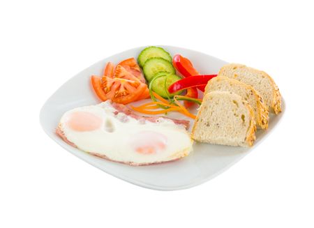 Fried eggs with bread and vegetable salad.の写真素材