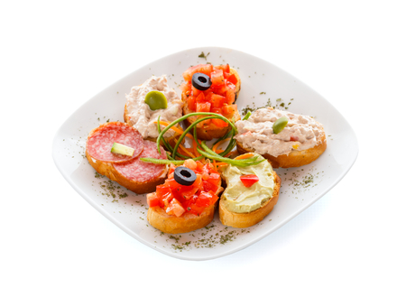 A plateful of mixed sandwitches: bruschette, guacamole, tuna and salami sandwich.の写真素材