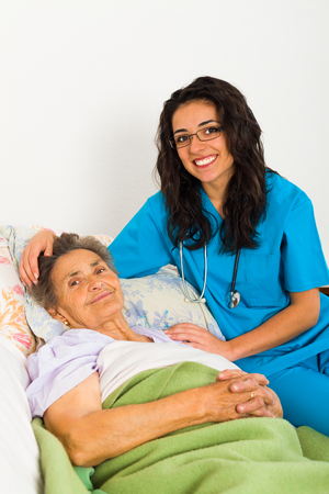 Nurse caring for sick elder lady in nursing home.の写真素材