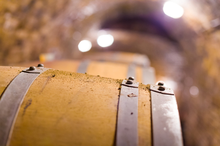 Oak barrel containing wine closeup background.