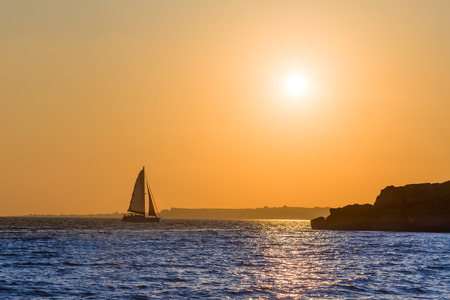 Distant boat with sails driven by the afternoon wind to home.の写真素材
