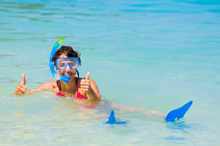 Happy girl in snorkeling gear showing thumbs-up.の写真素材