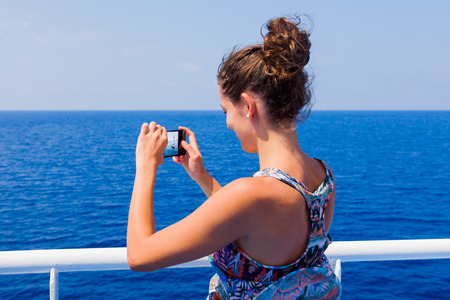 Beautiful girl photographing landscapes while traveling with ship.の写真素材