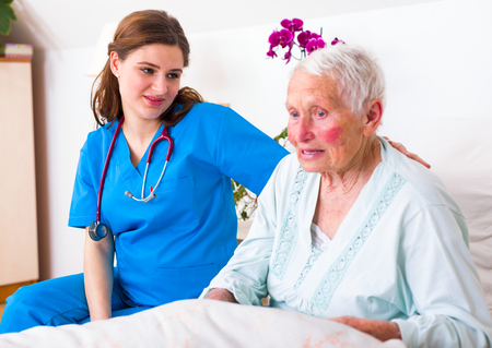 Geriatric doctor listening to the elderly woman patient with attention and care.の写真素材