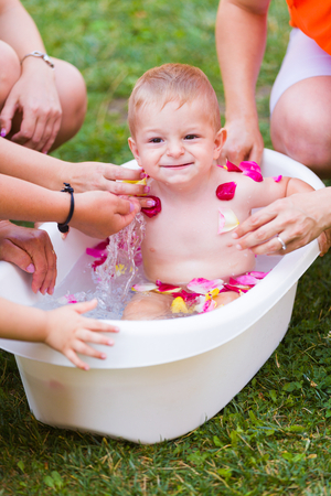 Joyful toddler having fun in the tub outdoors.の写真素材