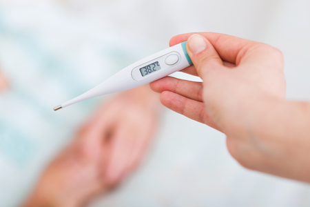 Carer checking elderly patients fever in the nursing home - virus infection.の写真素材