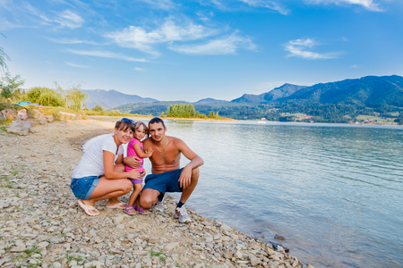 hapy family next to a mountin lake hiking and having fun.の写真素材