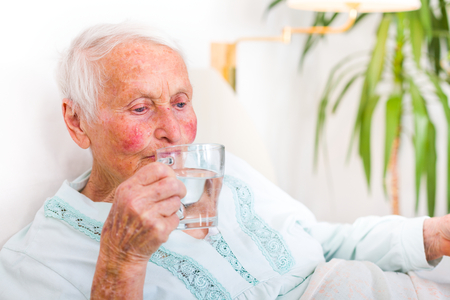 Senior woman hydratating herself, drinking fresh water.の写真素材