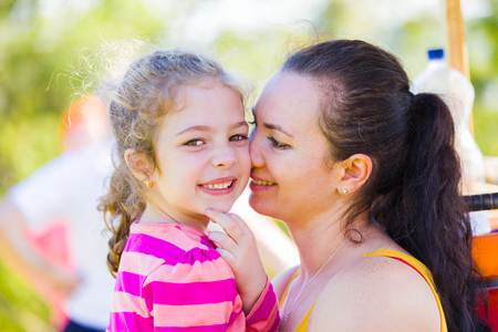 Loving mother holding her daughter, bonding with her.の写真素材