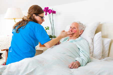 Helpful nurse caring for the senior woman in the nursing home.の写真素材