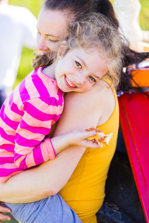 Mother and daughter hugging each other, bonding in a warm summer day.の写真素材