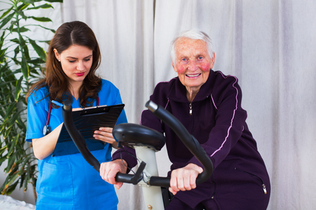 Geriatrician taking notes about the effort capacity of an elderly woman in a nursing home.の写真素材