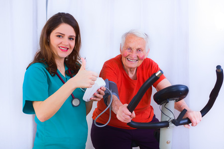 Elderly woman training, making effort, having hear heart condition, rate and blood pressure monitored by geriatric doctor.の写真素材
