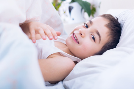 Happy child waking up in the morning fresh and reposeful to begin the day.の写真素材