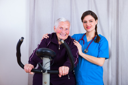 Kind nurse attending a senior woman's training in a nursing home.の写真素材