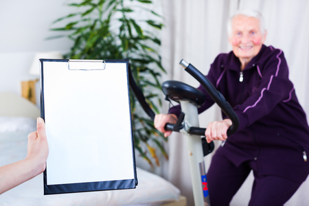Geriatrician taking notes about the effort capacity of an elderly woman in a nursing home.の写真素材
