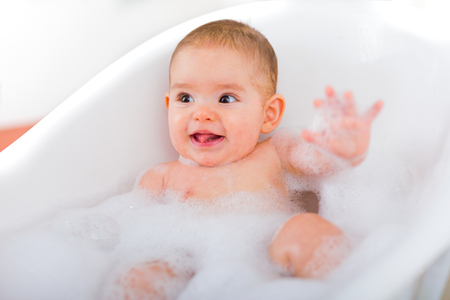 Happy little baby taking a bubblebath.の写真素材