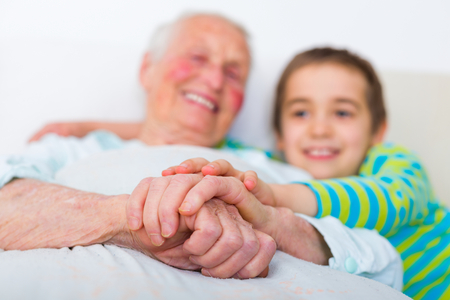 Little boy hugging elderly woman and supporting her.の写真素材