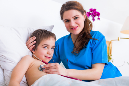 Pediatrician doctor winning the trust of little child by showing her what a stethoscope is for like a friend.の写真素材