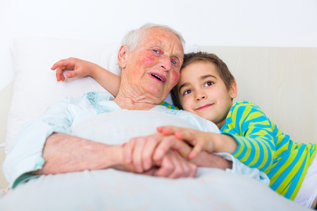 Grandmother telling bedtime stories to her grandson.の写真素材