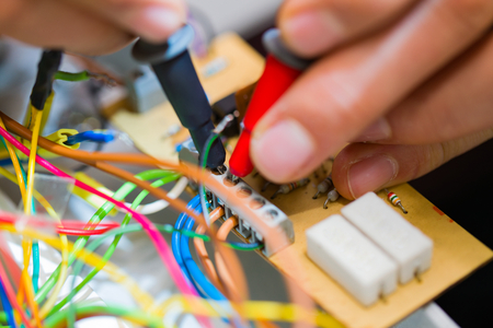 Electrician measuring electrical panels, detecting failure before fixing it.の写真素材
