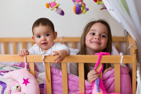 Two beautiful and happy siblings - sisters - waking up / laying down at morning / night.の写真素材
