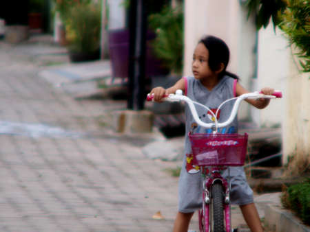 Lampung	Suamtra Selatan	Indonesia	-	05/19/2012	:	"
the girl gets on the bicycle, stops and looks to the right"のeditorial素材