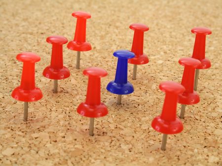 Pushpin standing out from the crowd of other pushpinsの写真素材