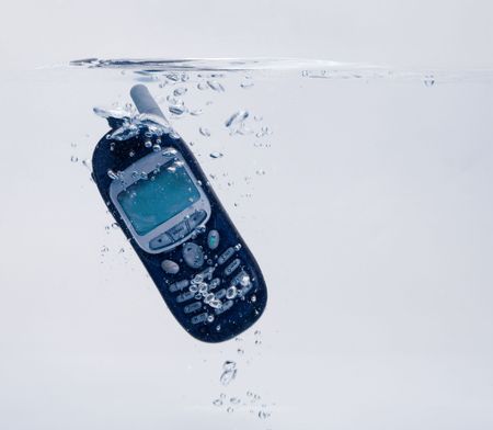 Phone splashing into water - concept for relaxing, taking time out or communication failure (with copyspace)の写真素材