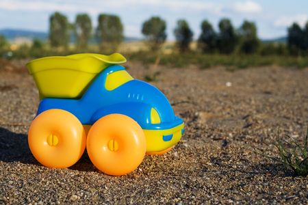 Toy car on a deserted playground at dusk - the perspective creates a reality-like, authentic feelingの写真素材