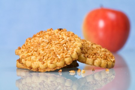 Peanut chips cookies and a red apple on reflective surface - closeupの写真素材