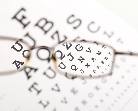 Blurry text clearing up through eyeglass - medical optics conceptの写真素材